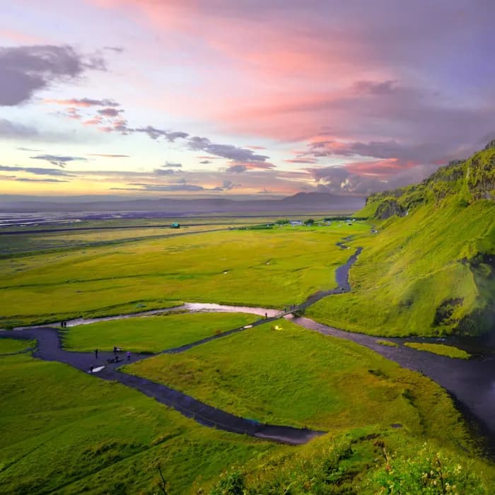 A river winding through green highlands at sunset in Iceland